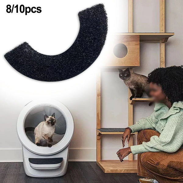 Black cat litter mat with a cat litter box, wooden cat tree, and a person sitting on a chair.